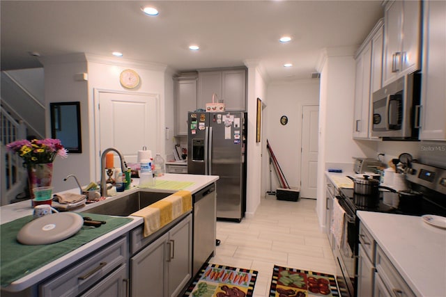 kitchen with crown molding, appliances with stainless steel finishes, sink, and gray cabinetry