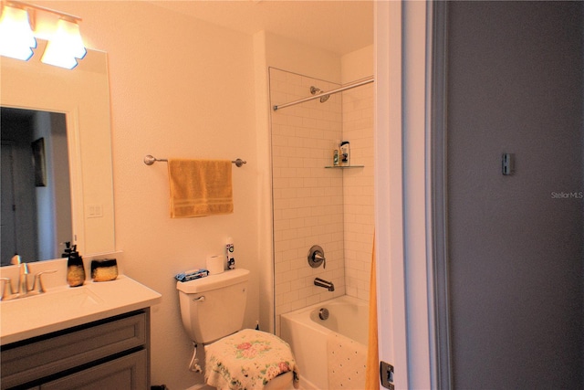 full bathroom featuring vanity, tiled shower / bath, and toilet