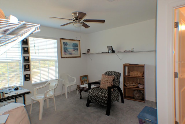 sitting room with ceiling fan and light carpet