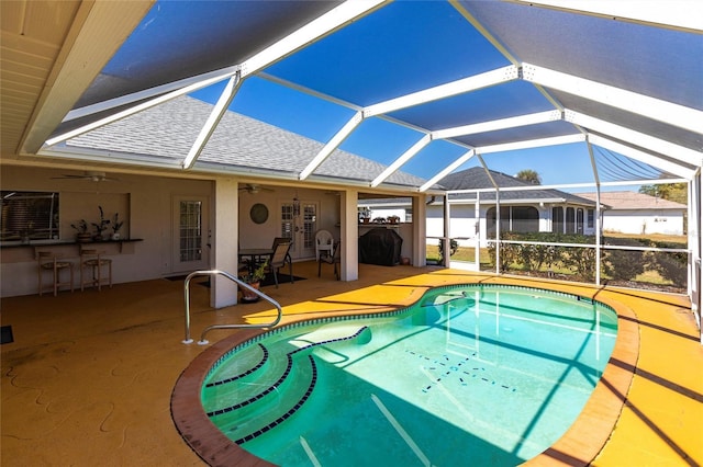 view of pool featuring a bar, ceiling fan, a lanai, and a patio area