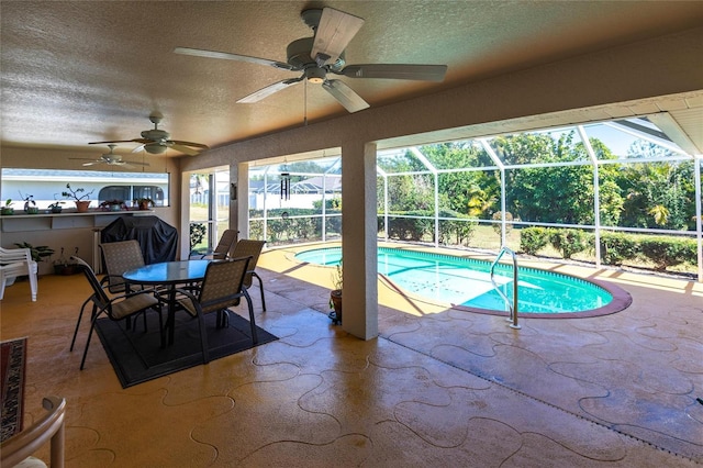 view of swimming pool with a patio area, ceiling fan, and glass enclosure