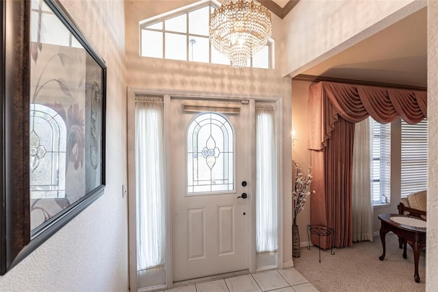 tiled foyer entrance featuring a notable chandelier and ornamental molding