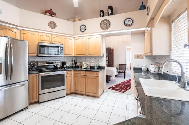 kitchen featuring tasteful backsplash, appliances with stainless steel finishes, light tile patterned flooring, and sink