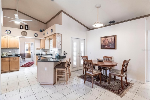 kitchen with ornamental molding, sink, a breakfast bar area, and kitchen peninsula