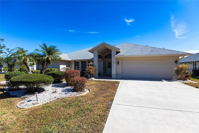 ranch-style house featuring a garage and a front lawn