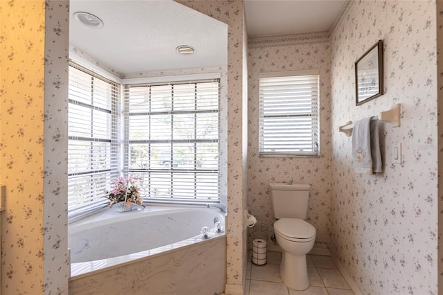 bathroom with tile patterned flooring, a bathtub, plenty of natural light, and toilet