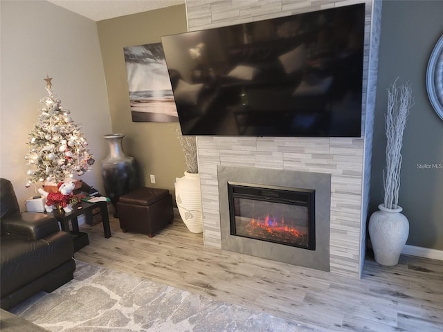 details with hardwood / wood-style floors and a tile fireplace