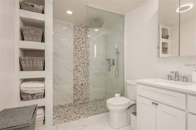 bathroom featuring vanity, toilet, and a tile shower