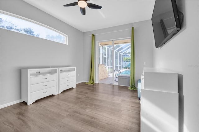 bedroom with multiple windows, access to exterior, and light hardwood / wood-style floors