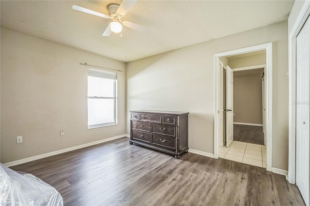 bedroom featuring ceiling fan, a closet, a textured ceiling, and light wood-type flooring