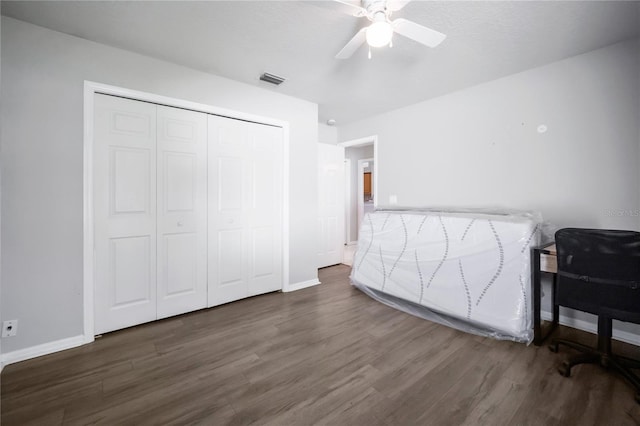 bedroom with dark hardwood / wood-style flooring, a closet, and ceiling fan