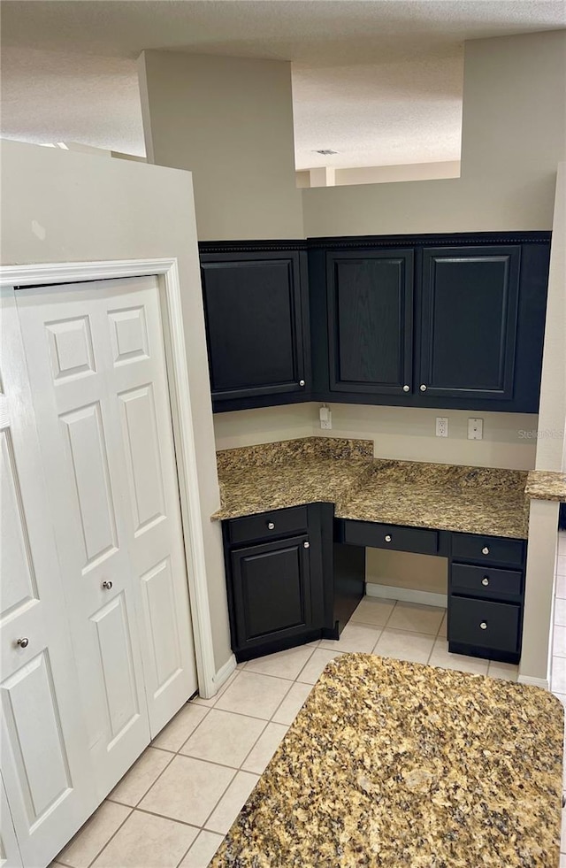 kitchen featuring built in desk and light tile patterned floors