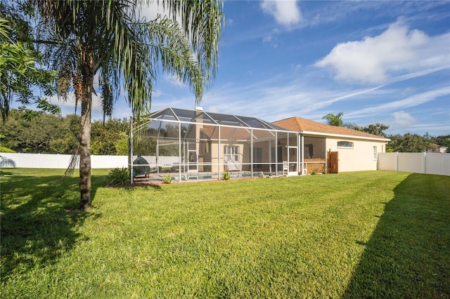 back of property with a lanai and a lawn