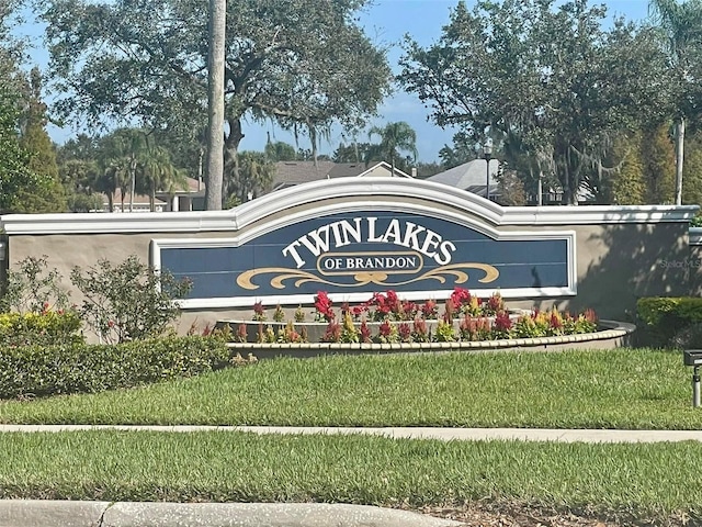 community / neighborhood sign featuring a lawn