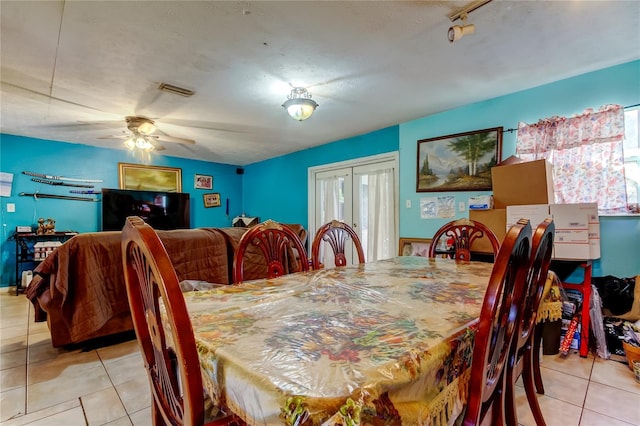 dining room featuring light tile patterned floors, a textured ceiling, and ceiling fan