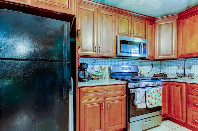 kitchen with decorative backsplash, stainless steel appliances, and light tile patterned flooring