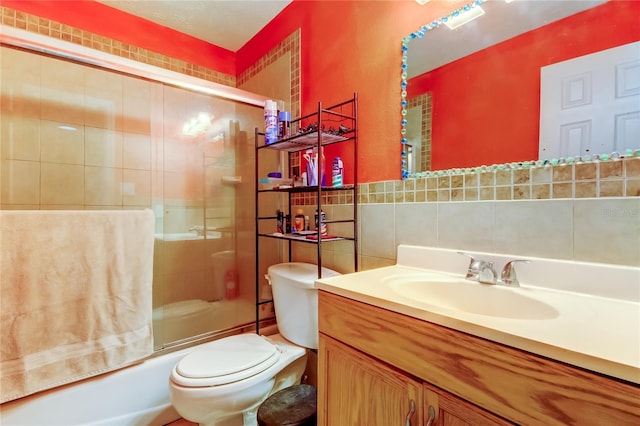 full bathroom with decorative backsplash, bath / shower combo with glass door, vanity, and toilet