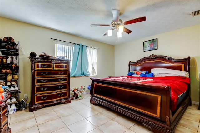 tiled bedroom with a textured ceiling and ceiling fan