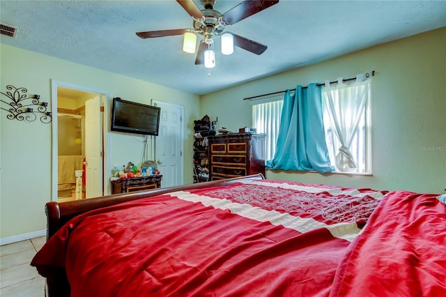 bedroom featuring connected bathroom, a textured ceiling, ceiling fan, and light tile patterned floors