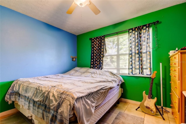 tiled bedroom with a textured ceiling and ceiling fan