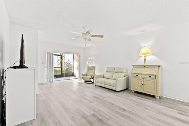 unfurnished living room featuring ceiling fan, a textured ceiling, and light wood-type flooring