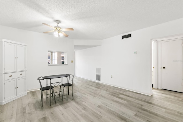 dining area featuring ceiling fan, a textured ceiling, and light wood-type flooring