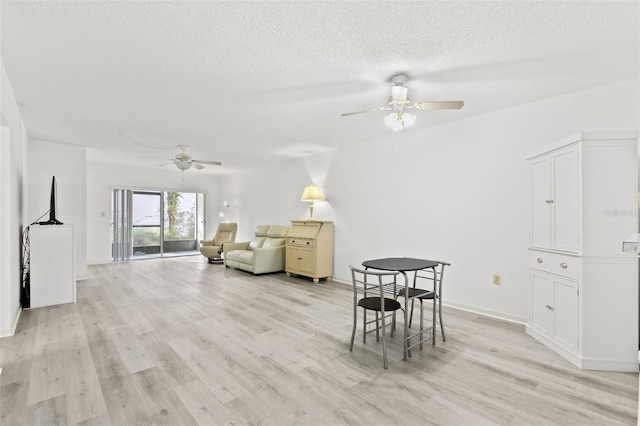 dining area with ceiling fan, light hardwood / wood-style flooring, and a textured ceiling