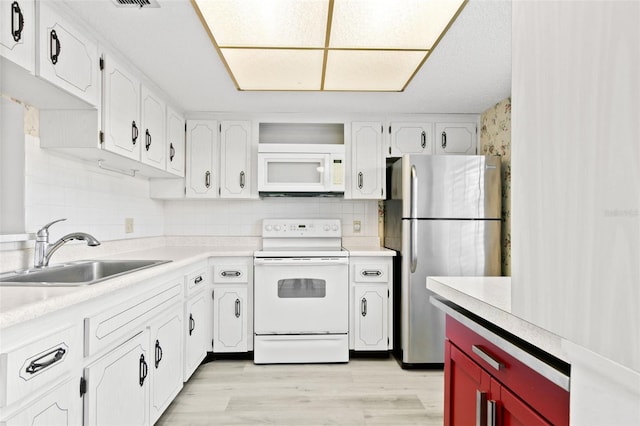 kitchen featuring sink, white cabinets, white appliances, and light hardwood / wood-style flooring