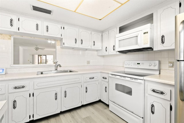 kitchen with white cabinetry, sink, backsplash, and white appliances