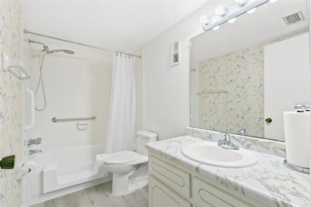 full bathroom featuring hardwood / wood-style floors, vanity, shower / tub combo, toilet, and a textured ceiling