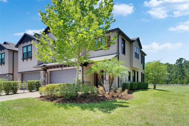 4899 Isola Ct, Wesley Chapel, FL 33543 - view of front of house featuring a garage, a front lawn, stucco siding, concrete driveway, and stone siding