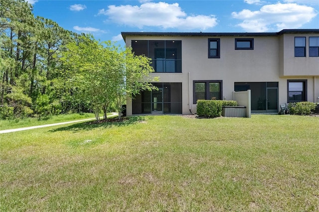 4899 Isola Ct, Wesley Chapel, FL 33543 - rear view of house featuring stucco siding and a lawn