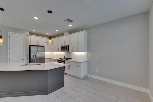 4899 Isola Ct, Wesley Chapel, FL 33543 - kitchen with stainless steel appliances, a sink, backsplash, light countertops, and baseboards