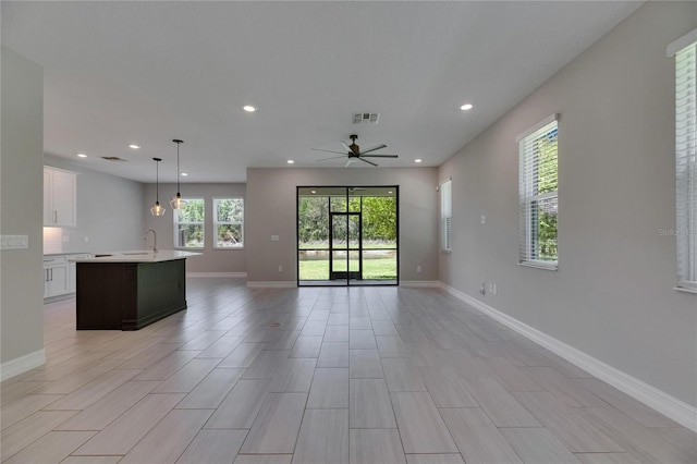 4899 Isola Ct, Wesley Chapel, FL 33543 - unfurnished living room with recessed lighting, a ceiling fan, a sink, and baseboards