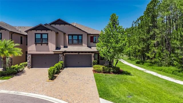 4899 Isola Ct, Wesley Chapel, FL 33543 - view of front of property featuring stucco siding, an attached garage, decorative driveway, a front yard, and stone siding