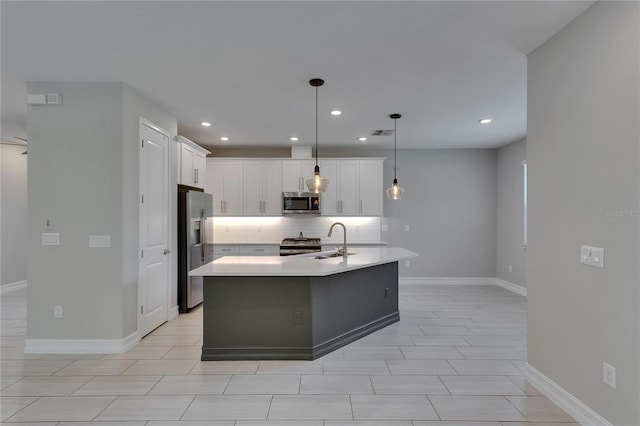 4899 Isola Ct, Wesley Chapel, FL 33543 - kitchen with stainless steel appliances, a sink, decorative backsplash, recessed lighting, and white cabinetry