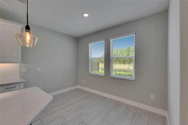 4899 Isola Ct, Wesley Chapel, FL 33543 - unfurnished dining area featuring baseboards, recessed lighting, and wood finish floors
