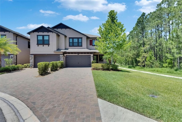 4899 Isola Ct, Wesley Chapel, FL 33543 - view of front of house with an attached garage, decorative driveway, a front lawn, and stone siding