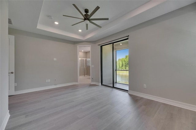 4899 Isola Ct, Wesley Chapel, FL 33543 - unfurnished room featuring ceiling fan, light wood-type flooring, a tray ceiling, recessed lighting, and baseboards