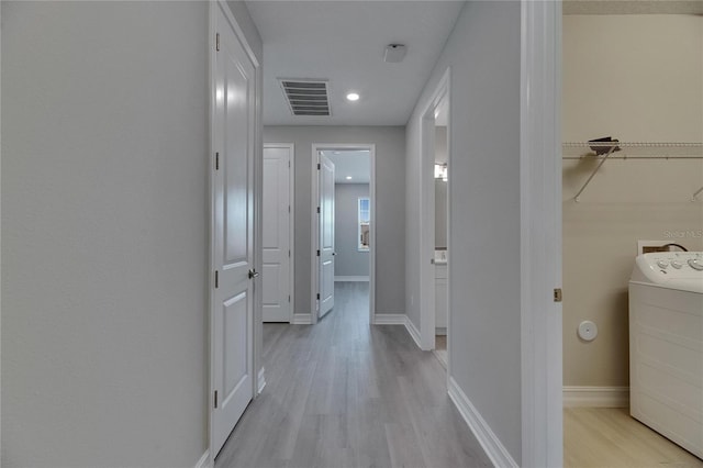4899 Isola Ct, Wesley Chapel, FL 33543 - hall with washer / clothes dryer, light wood finished floors, recessed lighting, and baseboards