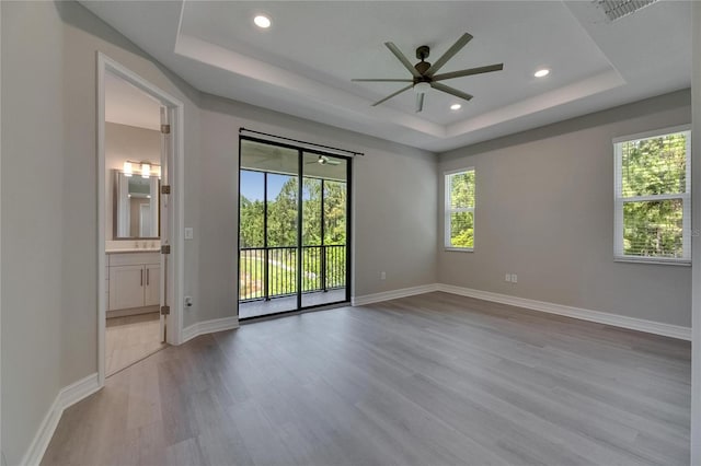 4899 Isola Ct, Wesley Chapel, FL 33543 - spare room with a tray ceiling, ceiling fan, wood finished floors, recessed lighting, and baseboards