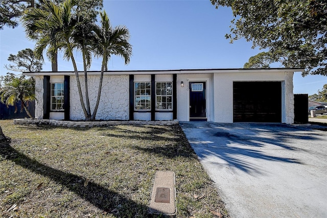 ranch-style house with a garage and a front yard