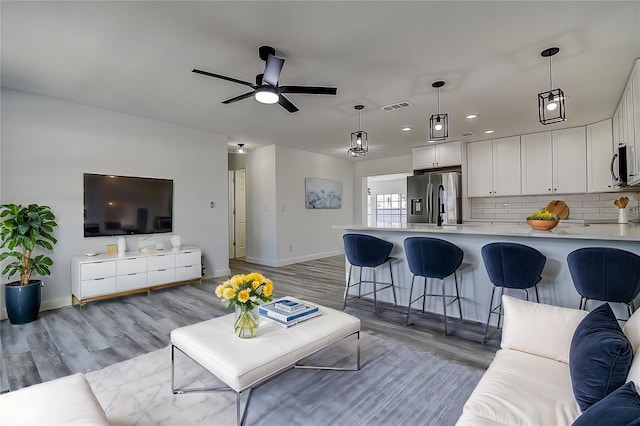 living room featuring ceiling fan and light wood-type flooring