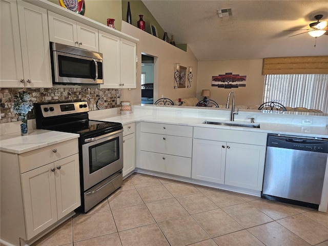 kitchen featuring stainless steel appliances, sink, decorative backsplash, and kitchen peninsula