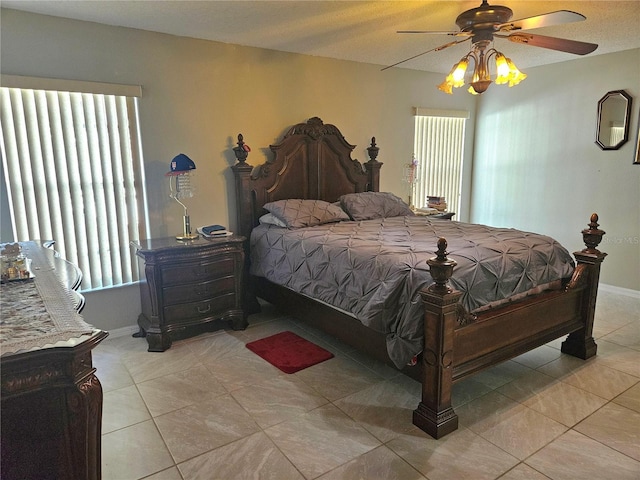 tiled bedroom with ceiling fan and multiple windows