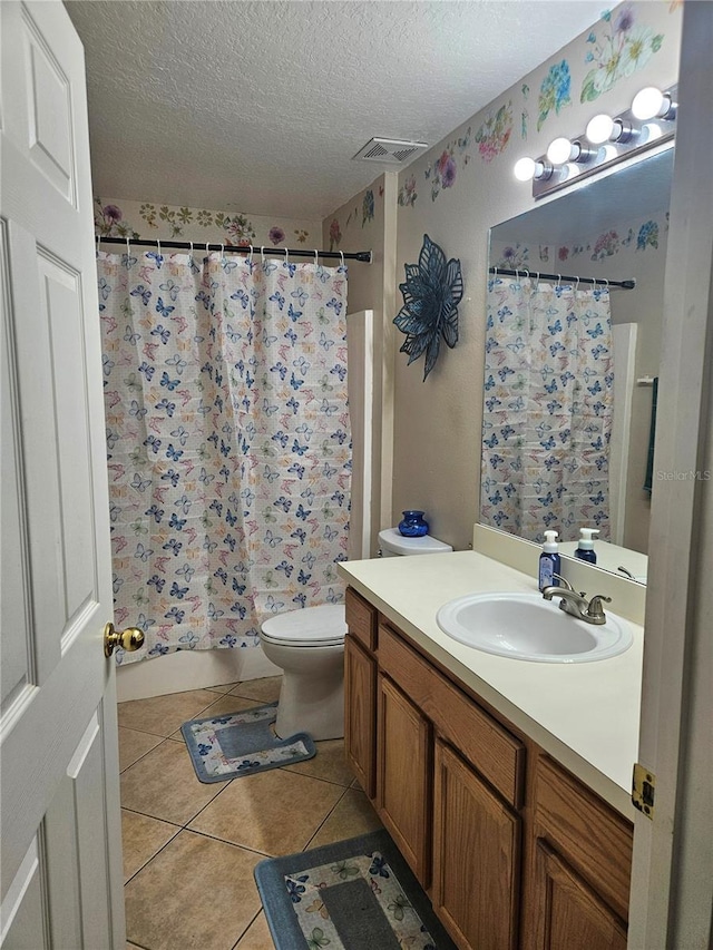 full bathroom featuring tile patterned floors, toilet, a textured ceiling, vanity, and shower / bath combo with shower curtain