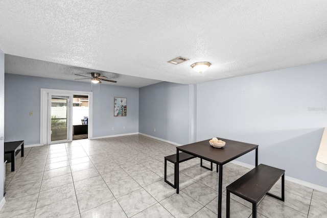 interior space with ceiling fan, a textured ceiling, and light tile patterned floors