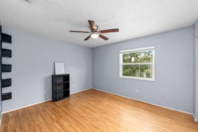 spare room with ceiling fan, a textured ceiling, and light wood-type flooring