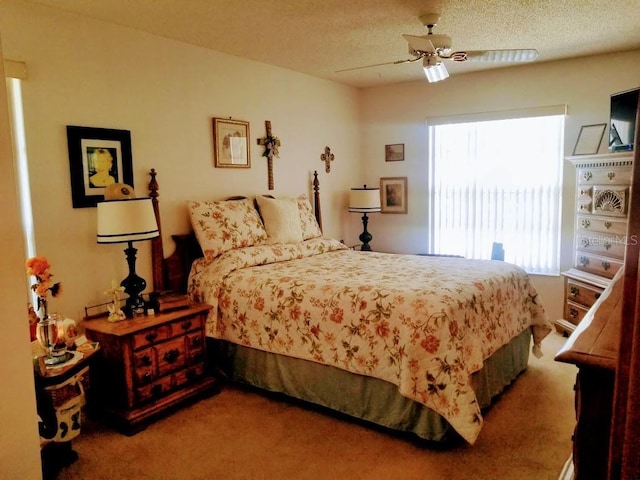 carpeted bedroom featuring ceiling fan and a textured ceiling