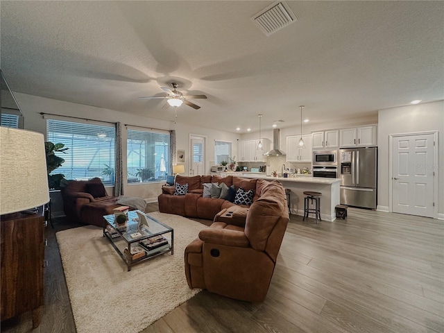 5709 Camila Song Ln, Tampa, FL 33625 - living room with a textured ceiling, wood finished floors, and visible vents